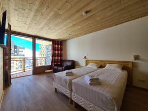 レ・メニュアールにあるChalet Le Graniticのベッドルーム1室(ベッド1台、椅子、窓付)