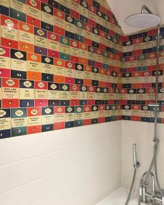 a bathroom with a tiled wall with different dishes on it at Claremont Coach House in Frensham +29 photos