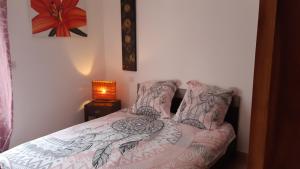 1 dormitorio con 1 cama con colcha y una flor en Appartement Maison Croisette, en Sainte-Maxime