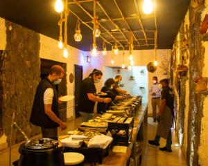 a group of people standing in a kitchen preparing food at Sama Heights Resort in Dār Sawdāʼ