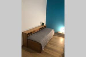 La Maison Bleue Sul Naviglio في كورسيكو: غرفة نوم بسرير وجدار ازرق