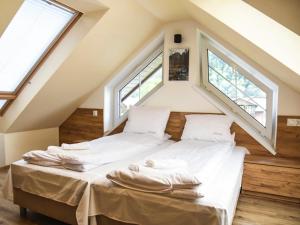 uma cama num quarto com duas janelas em Willa Szczepaniakówka em Szczawnica