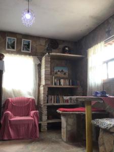 a living room with a book shelf and a table at Pousada Paraíso São thome in São Thomé das Letras