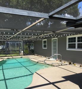 uma piscina com toldo e uma casa em Just Gotta Getaway em Port Orange