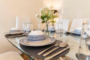 a glass table with plates and silverware on it at MPL Apartments - Queens Broadway F3 in Watford