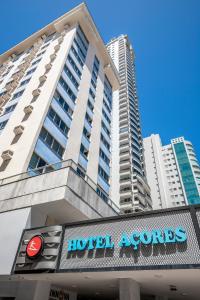 a hotelolis sign in front of a tall building at Hotel dos Açores in Balneário Camboriú