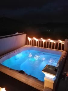 a hot tub on a balcony at night with lights at Hawthorn Hot tub Lodge Northumberland in Newton on the Moor