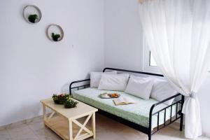 Habitación con cama con mesa y ventana en Filia's Family Apartment, en Archangelos