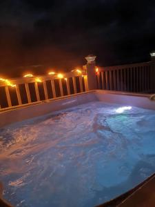 a hot tub on a deck at night at Hawthorn Hot tub Lodge Northumberland in Newton on the Moor