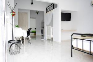 Una sala de estar blanca con una mesa y sillas. en Filia's Family Apartment, en Archangelos