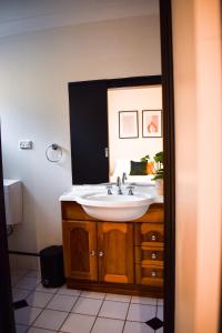 a bathroom with a sink and a mirror at The Sherwood Hotel in Lismore