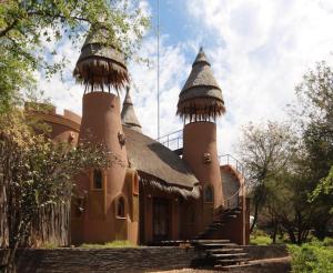 ein Haus mit zwei Türmen mit einem Dach in der Unterkunft hippomoon lodge game reserve in Hoedspruit