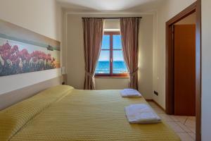 a bedroom with a large bed with a window at Locanda Le Palafitte in Bardolino