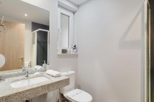 a white bathroom with a toilet and a sink at Modern studio in Arinsal of 40 m² with mountain view in Arinsal