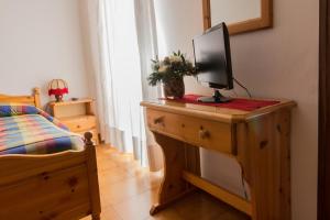 a bedroom with a desk with a television on it at Hotel Alpi - Asiago in Asiago