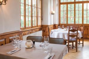una sala da pranzo con tavoli, sedie e finestre di Grand Hôtel & Kurhaus ad Arolla