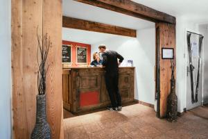 a man and a woman standing at a bar at Langley Hôtel Victors in Val-d'Isère