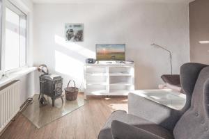 StahlbrodeにあるFerienhaus Rügenblickのリビングルーム(テーブル、椅子、テレビ付)