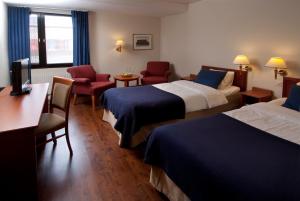Best Western Nya Star Hotel في أفيستا: غرفة فندقية بسريرين ومكتب وكراسي