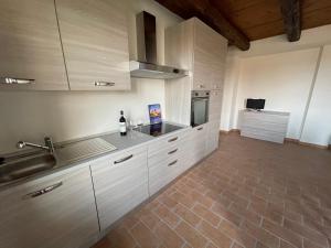 a kitchen with white cabinets and a sink at conGusto Apartments in Cherasco