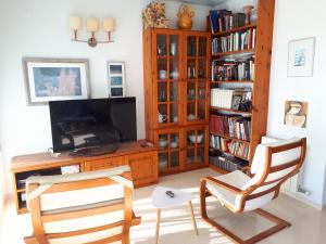ein Wohnzimmer mit 2 Stühlen und einem TV in der Unterkunft Casa Ana -Cubelles in Cubelles