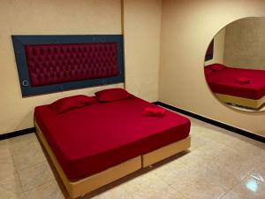 1 dormitorio con cama roja y espejo en Motel Emoções (Adults Only), en Fortaleza