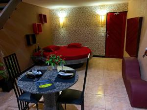 sala de estar con mesa y cama en Motel Emoções (Adults Only), en Fortaleza