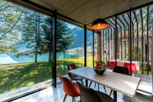 a room with a table and chairs and a large window at Hotel Le Prese in Poschiavo