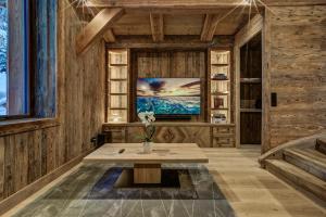 a living room with a table and a tv at Le Hameau des Nants in Chamonix-Mont-Blanc