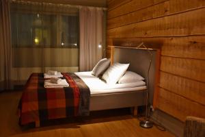 a bedroom with a bed with a wooden wall at Levi Suites Unna Mànnu in Levi