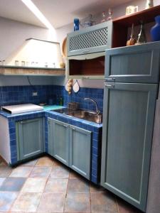 カストロヴィッラリにあるCasa degli aranciの青いタイルフロアのキッチン(シンク付)