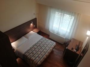 Hotel La Fonte في أوزيمو: غرفه فندقيه بسرير ونافذه
