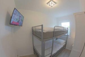 Zimmer mit einem Etagenbett und einem TV an der Wand in der Unterkunft KW4b Haus Cati in Dorum Neufeld
