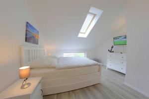 ein weißes Schlafzimmer mit einem Bett und einer Kommode in der Unterkunft KW4b Haus Cati in Dorum Neufeld + 19 Fotos