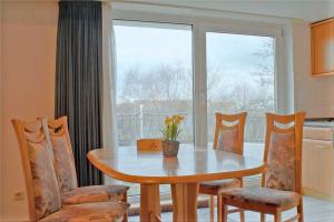 a kitchen with a table and chairs and a window at Seemöwe KD2-08 in Dorum Neufeld