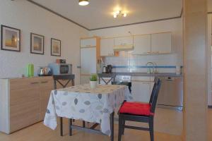 a kitchen with a table and two chairs and a kitchen with a table at FeWo Leuchtturm Wremen in Wremen