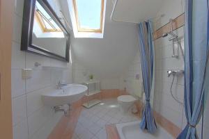 a bathroom with a sink and a toilet and a window at FeWo Leuchtturm Wremen in Wremen +10 photos
