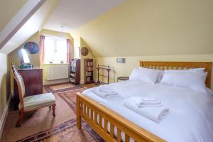 a bedroom with a large bed with towels on it at Beach House - Aldeburgh Coastal Cottages in Aldeburgh