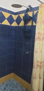 Baño de azulejos azules con cortina de ducha en Alborada minisuites en Guayaquil