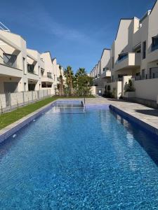 a swimming pool in front of some apartment buildings at Apartamento con solarium Villa Amalia in Torrevieja +27 photos