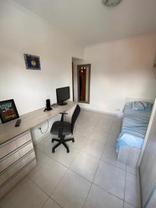 a bedroom with a desk and a bed and a computer at Hospedagem Granville in Sao Paulo