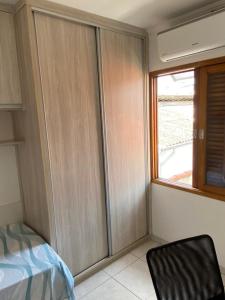 a bedroom with wooden cabinets and a window at Hospedagem Granville in Sao Paulo