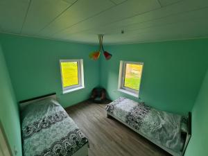 a bedroom with two beds and two windows at Sonda puhkemaja in Sonda