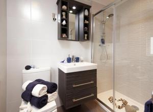 a bathroom with a shower and a sink and a toilet at Swanage Bay View Resort in Langton Matravers