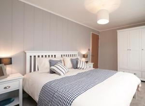 a bedroom with a bed with two pillows on it at Swanage Bay View Resort in Langton Matravers