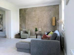 a living room with a couch and a wall at ApartmentInCopenhagen Apartment 113 in Copenhagen