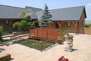 a fence in front of a house with a christmas tree at Chale Bay Farm in Ventnor