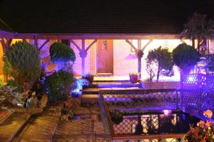 Chale Bay Farm في فنتنور: منزل مع شرفة مع أضواء أرجوانية عليه