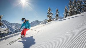 a woman is skiing down a snow covered slope at Ferienhaus Pichl in Bruck an der Großglocknerstraße