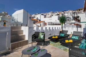 un patio avec des chaises et des tables sur un balcon avec des bâtiments dans l'établissement No 17 Competa, à Cómpeta